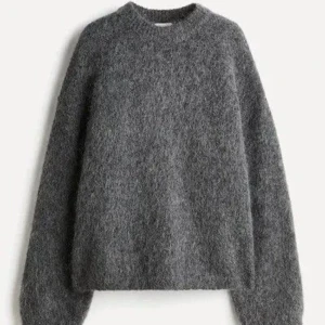 Grå stickad tröja med rund hals - Mjuk och fluffig grå stickad tröja med rund hals och långa ärmar. 