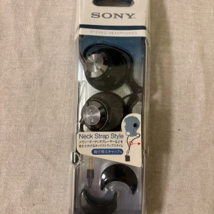 Sony Stereo Headphones MDR NQ1  - Nya Sony stereo hörlurar med neck strap-stil, kabelanslutna med 3,5mm kontakt. Levereras i originalförpackning. Perfekt för musik och samtal, ergonomisk design för bekväm användning. Köpta av mig i Tokyo.