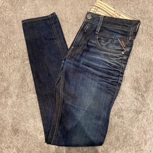 Replay Anbass jeans - Snygga Replay Anbass jeans i mörkblå tvätt med lätt slitning och klassiska fem fickor. Jeansen har slim passform, normal midja. Perfekta för dig som gillar en modern och stilren look.