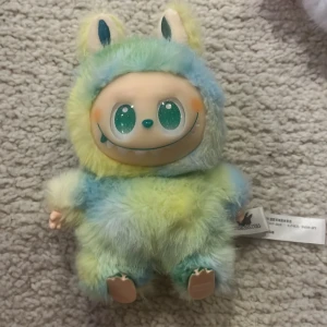 TheMonsters Serenity Plush - Söt samlarplush från TheMonsters, modellen Serenity. Mjuk, fluffig och i pastellfärger med stora glittriga ögon. Kommer med originaltagg och kartong. Mycket fint skick, inga synliga defekter eller slitage. Perfekt för samlare eller som present.