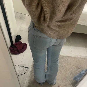 Ljusblå bootcut jeans - Säljer ett par ljusblå jeans med bootcut-modell och klassisk femficksdesign. Jeansen har låg midja och är tillverkade i mjukt denimtyg. Perfekta för dig som gillar en avslappnad och trendig look.