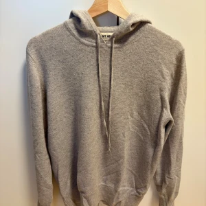 Soft Goat Kashmirhoodie - Mjuk och stilren grå hoodie från Soft Goat med huva och snörning. Tröjan har långärmade ribbade muddar och en klassisk loose passform. Perfekt för chill dagar och enkel att matcha med jeans eller joggers.