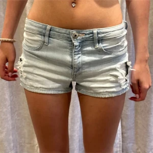 Ljusblå denimshorts med slitningar - Midjemått: 32 cm tvärsöver. Barnstorlek 152-passar mig som har XS