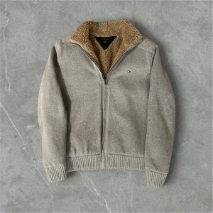 Grå fodrad kofta Tommy hilfiger - Tja, säljer denna snygga fodrade koftan från Tommy hilfiger. Storlek S men kan även passa M och för folk som är ca mellan 178-188🙌. Den har en väldigt mjuk och varm fordring som passar perfekt nu till vintern❄️. Priset är inte hugget i sten och hör av dig vid frågor//alex closet✨✨