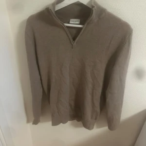 Beige half zip tröja John Henric - Snygg beige tröja från John Henric med half zip och hög krage. Tröjan är långärmad och har en stilren, klassisk look som passar perfekt till jeans. Den är liten i storlek Hör av dig vid minsta fråga! 