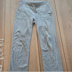 Grå mjukisbyxor Juicy Couture M - Grå mjukisbyxor från Juicy Couture med raka ben, snörning i midjan och stora fickor både fram och bak