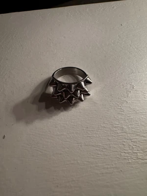 Edblad ring  - Snygg Edblad ring med nitar på ovansidan. Ringen har en bred och robust design som sticker ut och ger en edgy vibe. Perfekt för dig som gillar att addera lite attityd till din stil.