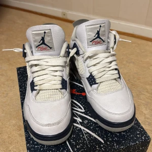 Nike Air Jordan 4 Retro Vit/Marinblå - Nike Air Jordan 4 Retro sneakers i vit och marinblå färg med detaljer i grått. Skorna har snörning, meshpaneler och Jumpman-logga på plösen och hälen. Tillverkade i skinn med platt sula och speckled detaljer på mellansulan och bakre panelen. Perfekt för dig som gillar klassiska och sportiga sneakers. Smutsig under där man går men ba tvätta med vatten sp är det rent o nytt priset kan sänkas