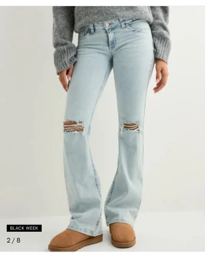 Bootcut ljusblå jeans med slitningar - Jeans med hål o rosa detalj på fickorna, förstora på mig som e 151. Storlek 32. Använda 3 gånger. Nypris 700kr. Öppen för bud!