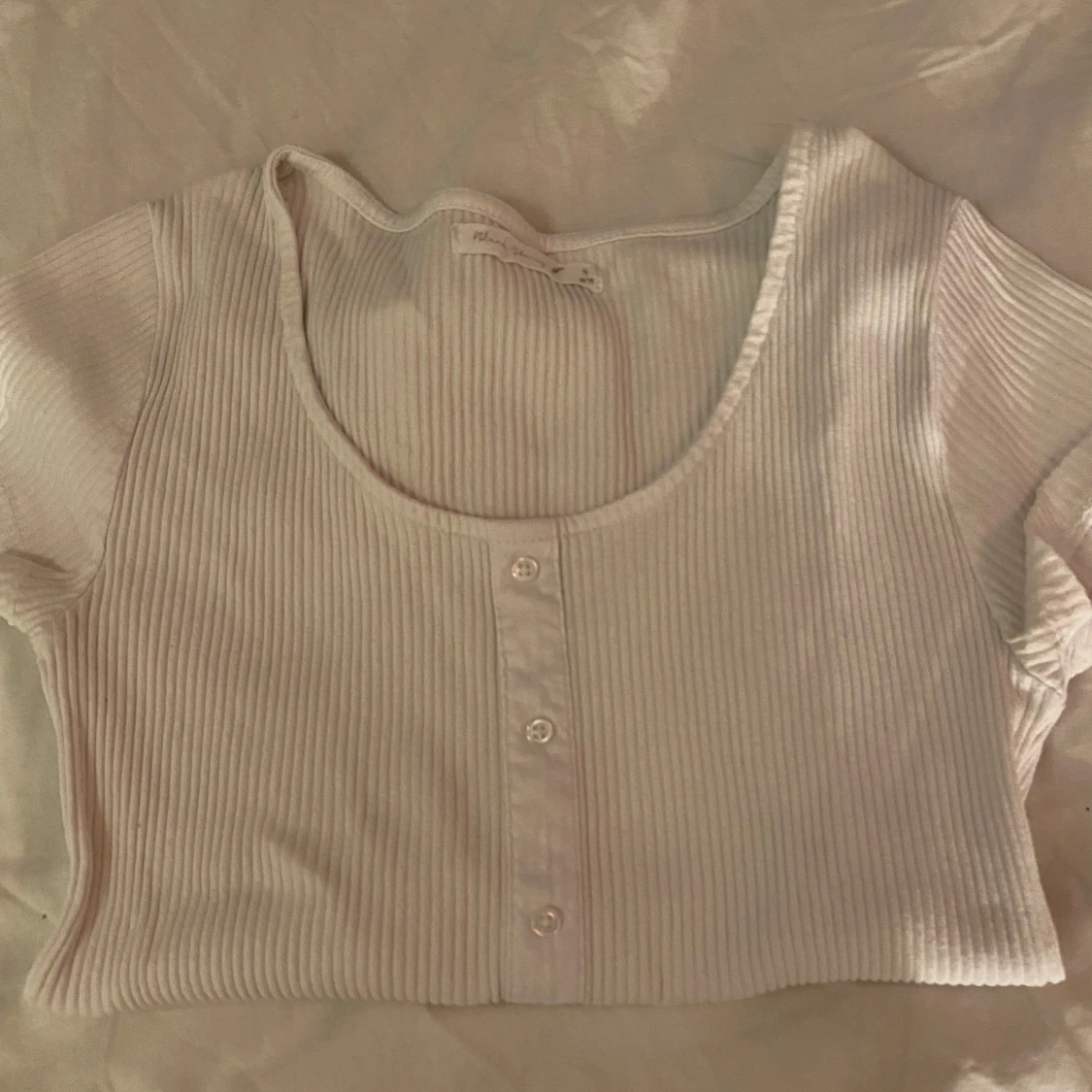 Vit ribbad topp med knappar . - 2