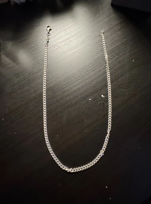 Klassisk silverfärgad kedja - Snygg halskedja i silverfärgat metall med stilren och enkel design. Kedjan har ett robust karbinlås och platta länkar som ger ett cleant och modernt intryck. Perfekt för dig som gillar minimalistiska smycken och vill ha något som funkar till alla outfits.