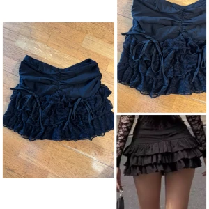 Svart volangkjol med spets och snörning S - Supersöt svart minikjol med flera lager volanger i spets och snygga snörningsdetaljer framtill. Kjolen har en tight passform upptill och voluminös nederdel som ger en riktigt trendig look. Perfekt för dig som vill sticka ut med en edgy och feminin stil. Korea brand