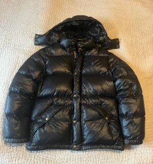 Glansig Ralph lauren jacka - Checka in mina andra jackor!                                                  Riktigt fet ralph lauren jacka perfekt till vintern, jackan är i väldigt bra skick bara en liten lagning på armen, men inget som syns. Tveka inte med frågor! Storleken är Xl ungdomstorlek passar Xs-S herr