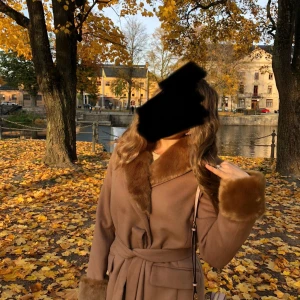 Beige kappa med fuskpäls från Holly & White by Lindex - Snygg beige kappa från Holly & White med fuskpäls på krage och ärmslut. Består av 50% Ull. Kappan har bälte i midjan, långa ärmar och två fickor framtill. Perfekt för dig som vill ha en classy och mysig look under hösten och vintern. Avtagbara pälsdelar. 