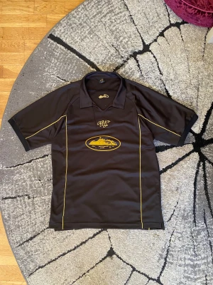 Corteiz Fotbollströja - || Säljer en svart fotbollströja från Corteiz med gula detaljer och broderad logga i bak. || Knappast buren, bara ett fåtal gånger || Storlek L, passar som en M || Vid fler frågor skicka ett DM 😃 ||