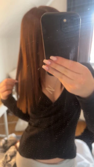 Svart långärmad topp med v-ringning - Säljer en svart långärmad topp med v-ringning. Sitter tight och har en enkel, stilren design som passar perfekt till jeans eller kjol. Materialet känns mjukt och följsamt mot kroppen. Perfekt för dig som gillar en clean och klassisk look.