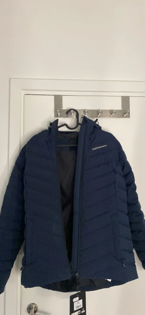 Helt ny blå Peak Performance Ski Frost Down Jacket  - Säljer denna helt nya Peak Performance Ski Frost Down Jacket. Den är oanvänd och i perfekt nyskick (endast provad hemma)  Anledning till försäljning: Köpte fel storlek och den passar tyvärr inte mig.  Nypris i butik är runt 5000 kr, så det här är ett riktigt bra pris.