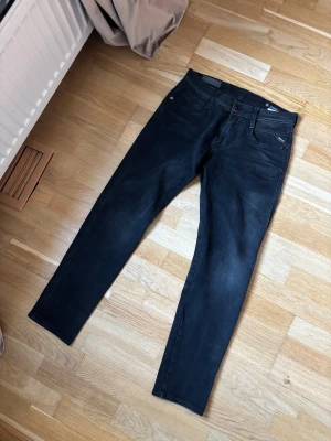 Svarta Replay anbass hyperflex jeans - Hej! Jag säljer dessa feta svart replay anbass hyperflex jeans i storlek 30/30. Jeansen är i modellen slim fit. Modellen på bilden är 178 cm lång och väger 70 kg. Skicket är 9/10 och de har inga defekter eller skador. Hör av dig vid frågor eller om du är intresserad! 🙂