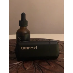 Tanrevel Face Mist med Tanning Liquid - Säljer en svart Tanrevel face mist-maskin, och skickar även med en flaska Tanning Liquid (flaskan är ej full, ca. 1/3 kvar). Enheten är stilren och kompakt, perfekt för att ge ansiktet en jämn solkysst ton. Maskinen är använd högst 2 gånger.  