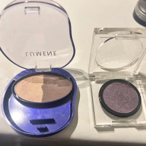 Duo och singelögonskugga Lumene & Invima - Säljer två ögonskuggor: en Lumene Arctic Duet i nyansen Veil of Mist med två matta bruna toner i oval blå plastförpackning, samt en Invima Eye Focus i färgen 50 Metal Mauve, en skimrande lila singelskugga i transparent ask.