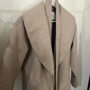 Kort kappa - Kommer ej till användning längre, smått nopprig på framsidan 