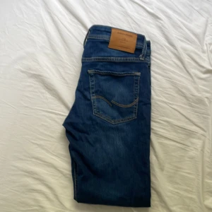 Blåa slim fit jeans från Jack & Jones - Snygga slimfit blå jeans från Jack & Jones . Perfekt passform och stilren look för dig som gillar en enkel men trendig vibe. Riktigt sköna jeans och enkla att få en snygg outfit till, passar med alla färger