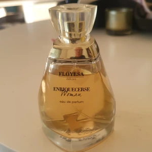 Enriquecerse Woman Eau de Parfum - Enriquecerse Woman beskrivs som en ultrafeminin doft med toppnoter som kombinerar sensualitet och styrka, lämplig för en "boss lady".  Denna typ av parfym kan påminna om andra välkända dofter, som till exempel Kenzo Flower när det gäller "Etre Florissant"-varianten. 