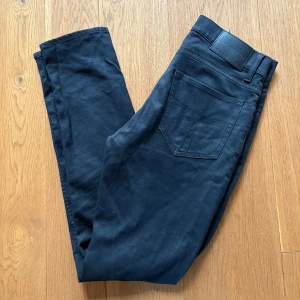 Svarta jeans från Tiger of Sweden - Snygga svarta jeans från Tiger of Swede. Byxorna har en rak passform och är tillverkade i mjuk bomull med lite stretch för extra komfort. Storlek: 29/32