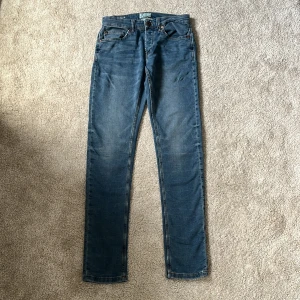 Blå jeans från only & sons - Snygga blå jeansbyxor från only & sons med klassisk femficksdesign och raka ben. Jeansen har normal passform, bälteshällor och dragkedja med knapp framtill. Perfekta till en avslappnad stil och funkar året runt. Oslagbart bra pris som alla har råd med! Storleken är 31/34 och är slim fit 