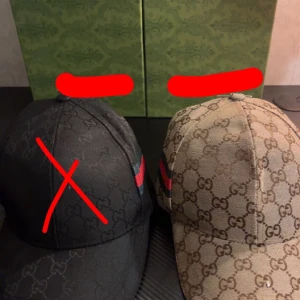 Beige keps - Säljer en helt oanvänd keps med box. Den har en böjd skärm och en röd-grön rand på sidan som ger en lyxig vibe. Perfekt för dig som vill sticka ut med designeraccessoar.