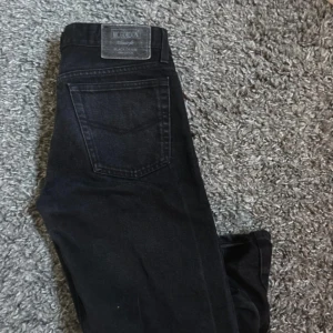 Svarta jeans från Mc Gordon - Svarta jeans från Mc Gordon i klassisk femficksmodell. Jeansen är tillverkade i bomull och har en rak passform med dragkedja i gylfen. Snyggt diskret läderpatch bak i midjan och stilren look som funkar till det mesta.