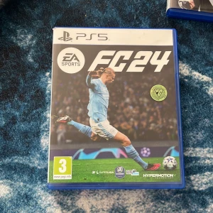 EA Sports FC 24 PS5 - EA Sports FC 24 till PlayStation 5 i mycket fint skick. Komplett med originalfodral och skiva utan synliga repor. Upplev den senaste fotbollssimuleringen med autentiska lag, ligor och Hypermotion-teknologi. Perfekt för fotbollsfans och gamers.