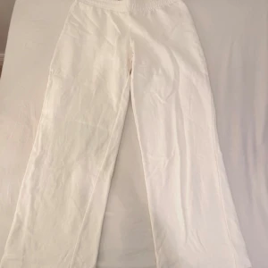 Vita mjukisbyxor från BikBok - Vita mjukisbyxor från BikBok. Byxorna har en loose och wide passform med raka, vida ben. Tillverkade i mjukt bomullsmaterial som känns skönt mot huden. Perfekta för en chill och avslappnad stil. Använd max 2 gånger!