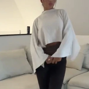 Vit croppad tröja med vida ärmar - Säljer en vit croppad tröja med supervida ärmar och hög hals. Det är som en poncho , slutsåld på Gina 