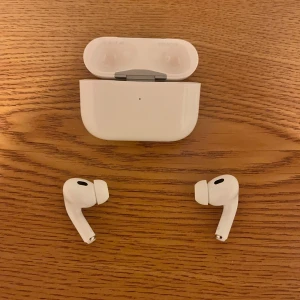 AirPods Pro - Apple AirPods Pro i mycket fint skick, har aldrig använt dom, komplett med originalförpackning, laddningsetui, extra öronproppar och laddkabel. Trådlösa hörlurar med aktiv brusreducering och hög ljudkvalitet. Inga repor eller skador, redo att användas direkt 