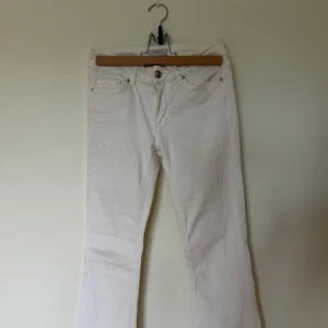 Vita bootcut jeans med råa kanter - Snygga vita jeans med bootcut-modell och klippta byxben, fransiga benslut.