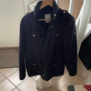 Field jacket J.Lindberg - Säljer denna as feta  J.Lindberg jackan, perfekt för sommarkvällar! Storlek s men passar m! Skicket är jätte bra förutom att det finns en skada på armen som man ser på sista bilden, inget men märker när man har på sig den!