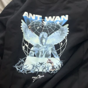 Svart Ant Wan hoodie med tryck - Svart hoodie från Ant Wan med stort grafiskt tryck i blått och vitt på ryggen.  Från hans första konsert i Avicii arena 2023! Pris kan självklart diskuteras 