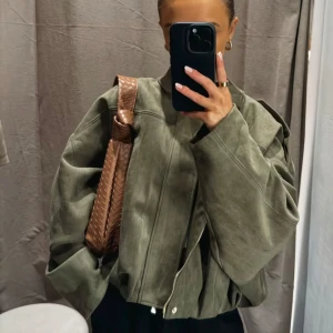 Zara mockajacka - Säljer en riktigt snygg khaki mockajacka med oversized passform och långa ärmar. Jackan har en cool, boxig siluett och dragkedja framtill. Perfekt för dig som gillar streetstyle och vill ha en jacka som sticker ut.
