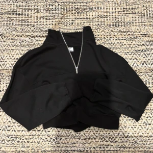Svart croppad half zip hoodie H&M Divided - Svart croppad hoodie från H&M Divided med half zip-dragkedja och hög krage. Tröjan har lång ärm och ribbade muddar. Aldrig använt❣️ 