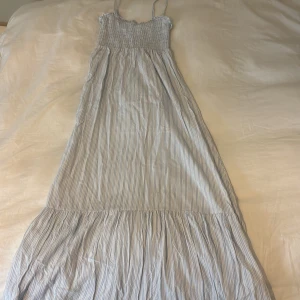 Långrandig sommarklänning med smock - ljusblå och vit randig långklänning