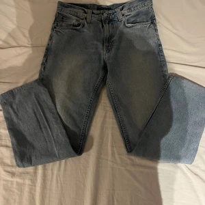 Nudie jeans straight fit - Nudie jeans i ljusblå tvätt med rak passform och fem fickor. Jeansen har knappgylf, normal midja och nudie patch baktill. Tillverkade i slitstarkt bomullsjeansmaterial, perfekt för en avslappnad och tidlös look.