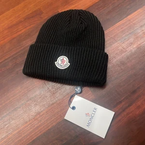 Moncler mössa/beanie - Snygg svart Moncler mössa till vintermånaderna❄️                                           Tveka inte med att kontakta vid frågor eller funderingar. Fraktar snabbt📦. Kom med bud priset är inte hugget i sten! Storlek: One size fits all. Köpt är Köpt👈👈