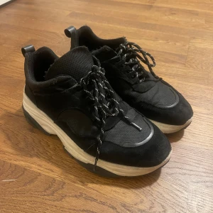 Svarta sneakers från Samsøe Samsøe - Chunky svarta sneakers från Samsøe Samsøe med vit och tjock sula. Ovandel i mesh och mocka, snörning med svarta och vita skosnören. Storlek 43