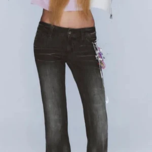 Svarta/grå bootcut jeans med låg midja - Snygga svarta/grå jeans med bootcut passform och låg midja. Vid intresse kan fler bilder skickas! Helt slutsålda på hemsidan