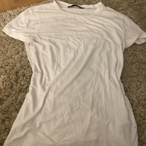 Vit basic t-shirt från 157 - En klassisk vit t-shirt från 157 i storlek S. T-shirten har rund halsringning och korta ärmar, tillverkad i mjuk bomull. 