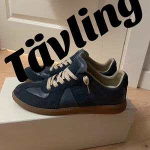 Mörkblå sneakers med beige snörning maison margiela(tävling) - För att delta: följ Plick och TikTok(Zanos sellout). Likea detta inlägg och alla på TikTok 