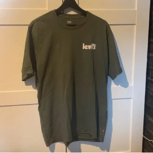 Levis T-shirt  - Snygg grön t-shirt från Levi's med vit logga tryckt på bröstet. Klassisk rund hals och korta ärmar. Tillverkad i mjuk bomull som känns skön mot huden. Perfekt för dig som gillar enkel och stilren design.