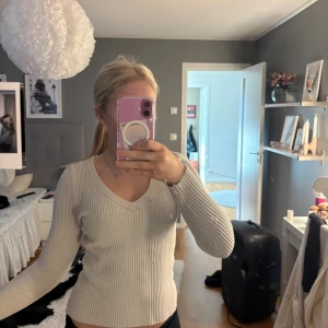 Beige ribbad stickad tröja från Cubus  - Säljer en beige ribbad stickad tröja från Cubus  i storlek XS. Tröjan har v-ringad hals, långärmade ärmar.