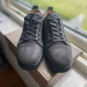 Grå mockasneakers från Christian Louboutin - Säljer ett par grymma grå Louboutins! Storlek 46, men de är små i passformen – sitter bäst på dig som vanligtvis har 45. Perfekta för dig som vill sticka ut med stil! 